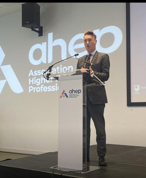 Dewi Knight speaking at lectern. 